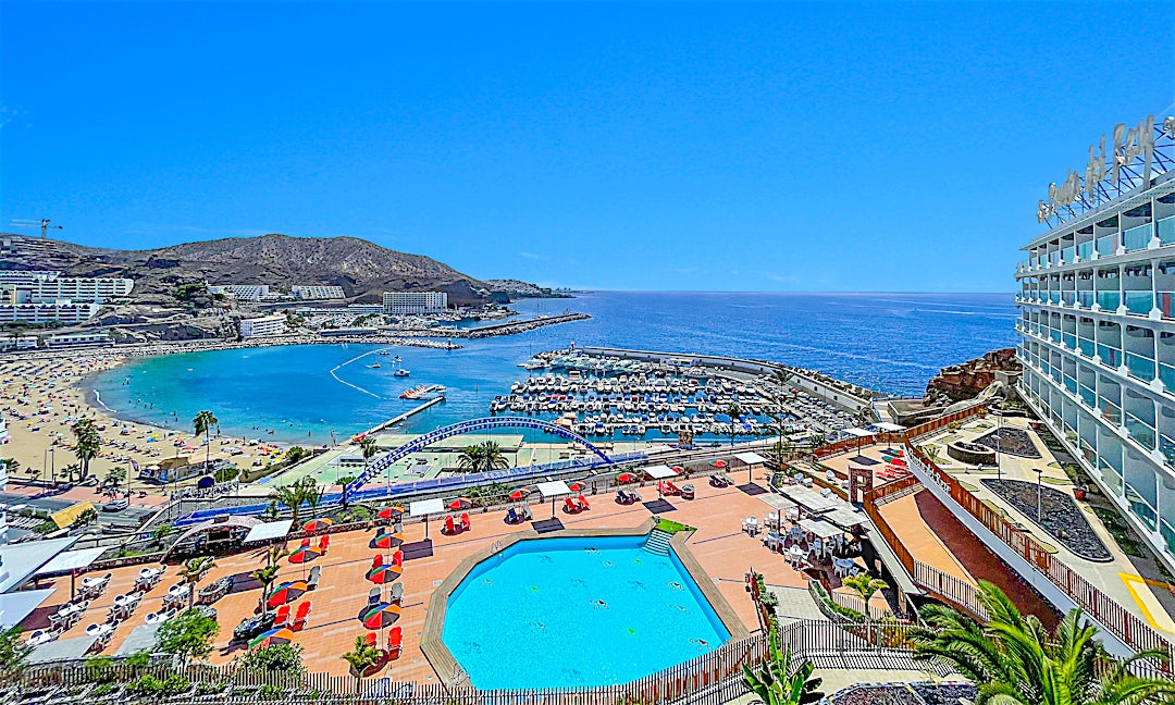 Panoramaudsigt over Punta del Rey med stor swimmingpool, blåt vand, solrige omgivelser