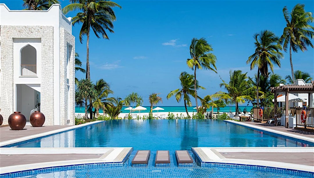 Poolområde med palmer på LUX* Marijani Zanzibar på Zanzibar.